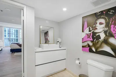 a bathroom with a painting of a woman brushing her teeth at Unforgettable! Water & Park Views, 4 Bedrooms! in Miami