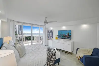 a white bedroom with a large bed and a tv at City of Dreams! Renovated With Water & Park Views in Miami