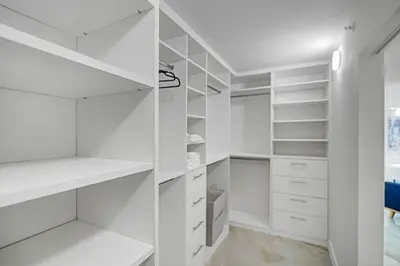 a white walk in closet with white shelves at City of Dreams! Renovated With Water & Park Views in Miami