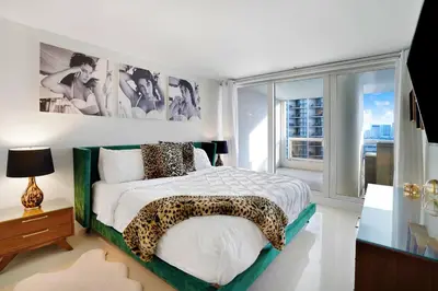 a bedroom with a bed with a leopard print blanket at Some Like It Hot! Miami Skyline & Water Views 4BR in Miami