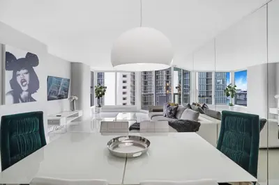 a white living room with a table and a couch at Life Is Gucci! Gorgeous WATER VIEWS Miami Condo! in Miami