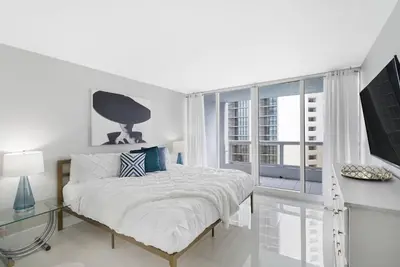 a white bedroom with a bed and a window at Life Is Gucci! Gorgeous WATER VIEWS Miami Condo! in Miami