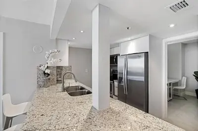 a kitchen with a sink and a stainless steel refrigerator at Champagne & Ice! Water Views, 2 Private Balconies! in Miami