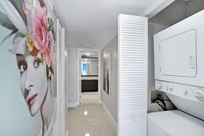 a white hallway with a painting of a woman at Champagne & Ice! Water Views, 2 Private Balconies! in Miami