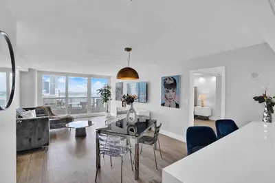 a white living room with a table and chairs at Big Energy! Water Views and Newly Renovated! in Miami