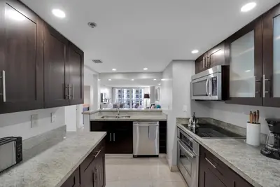 a large kitchen with wooden cabinets and stainless steel appliances at Hello Gorgeous! Water & City Skyline Views! in Miami