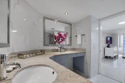 a bathroom with a sink and a large mirror at Hello Gorgeous! Water & City Skyline Views! in Miami