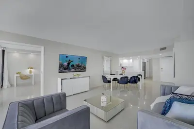 a white living room with a bed and a dining room at Velvet Sky! Water & Park Views! in Miami