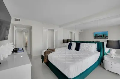 a white bedroom with a large bed and a table at Velvet Sky! Water & Park Views! in Miami