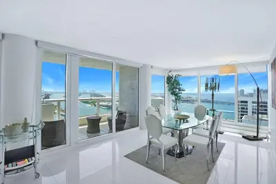 a dining room with a table and views of the ocean at Spectacular! Penthouse with Direct Water Views! in Miami