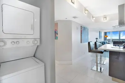 a white kitchen with a sink and a dishwasher at Spectacular! Penthouse with Direct Water Views! in Miami