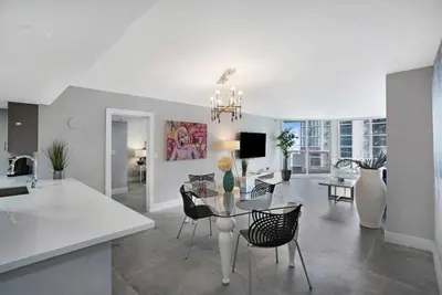 a kitchen and living room with a table and chairs at Blue Moon! In the lap of luxury and brand new! in Miami