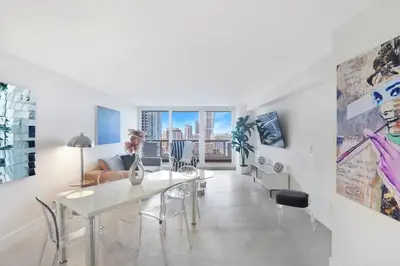 a white living room with a table and a couch at Sweet Dreams! Renovated with Water Views in Miami