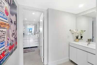 a white bathroom with two sinks and a mirror at Sweet Dreams! Renovated with Water Views in Miami