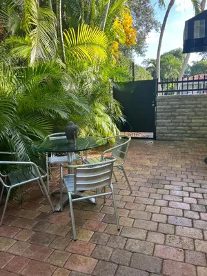 a patio with a table and chairs and palm trees at VILLA GUILLA in Miami