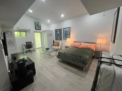 a bedroom with a bed and a living room at VILLA GUILLA in Miami