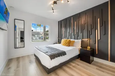 a bedroom with a large bed and a mirror at Flamingo's Resort -Htd Pool, 5 Bedrooms, Game Room, Baby Items , BBQ in Miami