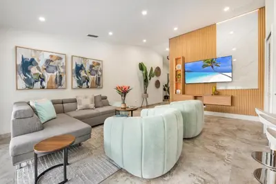 a living room with a couch and a tv at Flamingo's Resort -Htd Pool, 5 Bedrooms, Game Room, Baby Items , BBQ in Miami