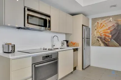 a kitchen with a sink and a microwave at Sunset Oasis with 2BR, Balcony, Pool, Perfect Getaway in Hallandale Beach