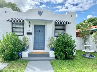 a white house with a blue door at Gorgeous Private Room, near the Airport - Free parking - 02 in Miami