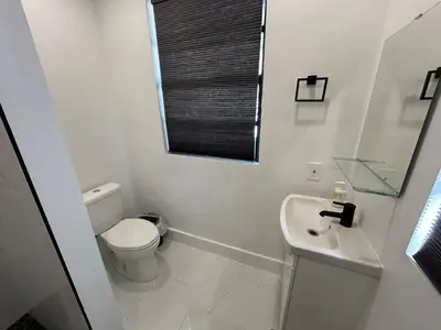 a white bathroom with a toilet and a sink at Cozy Private Room, near the Airport - Free parking - 02 in Miami