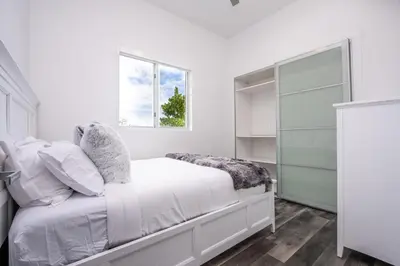 a white bedroom with a bed and a window at Modern 4-Bedroom Townhouse with Pool! in Miami
