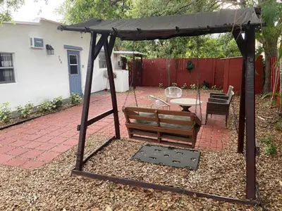 a swing and a table in a backyard at Cozy Private House near Miami Airport - Free parking - 02 in Miami