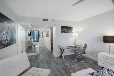 a living room with a table and a desk at Miami Vice! Totally Renovated, Water & Park Views! in Miami