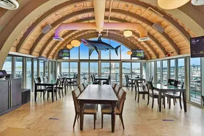 a restaurant with tables and chairs and a large room with windows at Miami Vice! Totally Renovated, Water & Park Views! in Miami