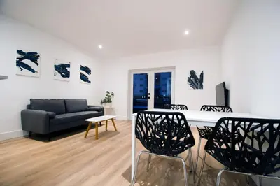 a living room with a couch and a table and chairs at Casa Canal in North Miami Beach