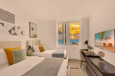 a bedroom with two beds and a desk and a window at Wrap Around BalconyParadise Beach Amazing Pools in Hollywood