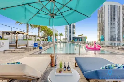 a pool with a blue umbrella and chairs and a pool at High Floor with Stunning View Pools Near Beach in Hollywood