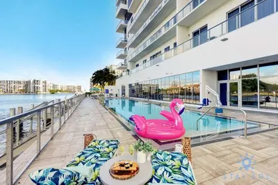a swimming pool with a table and chairs next to a building at High Floor with Stunning View Pools Near Beach in Hollywood