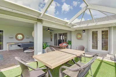 a patio with a wooden table and chairs at Pet-Friendly Miami Home with Hot Tub and Pool Table in Miami