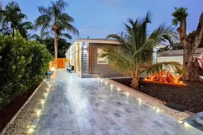a house with a courtyard with a palm tree and lights at Blue Ocean Vacation Home 2 in Fort Lauderdale