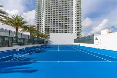 a tennis court in front of a tall building at 23rd-Floor Views • Pool Gym Beach Service in Hollywood