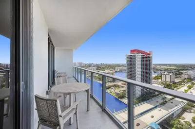 a balcony with a table and chairs and a view of a city at 23rd-Floor Views • Pool Gym Beach Service in Hollywood