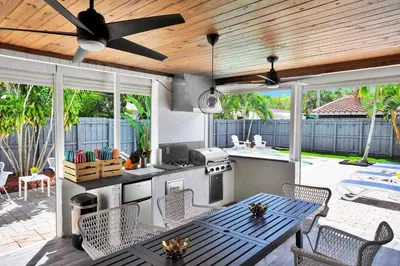 a patio with a table and a kitchen with a ceiling at Outdoor Paradise in Fort Lauderdale