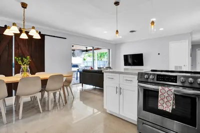 a kitchen and dining room with a table and a stove at Outdoor Paradise in Fort Lauderdale