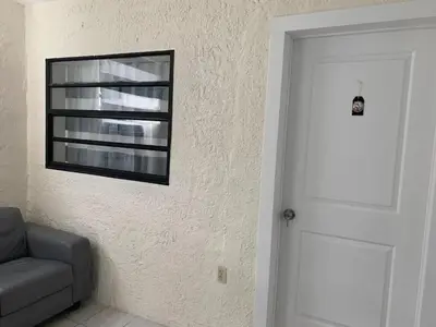 a door to a room with a couch and a window at Cozy rooms in cute house, close to Miami airport - Free parking in Miami