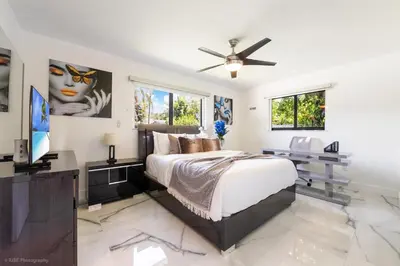 a bedroom with a large bed and a television at The Palms -Mini Golf , Foosball Table, Heated Pool ,Baby items ,BBQ in Miami