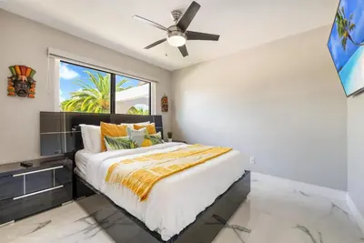 a bedroom with a bed with a ceiling fan at The Palms -Mini Golf , Foosball Table, Heated Pool ,Baby items ,BBQ in Miami