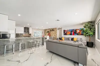 a living room with a couch and a kitchen at The Palms -Mini Golf , Foosball Table, Heated Pool ,Baby items ,BBQ in Miami