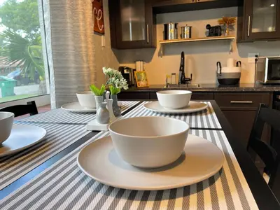 a table with bowls and plates on it in a kitchen at Orange You Glad you came in Miami