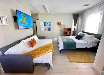 a bedroom with two beds and a couch in it at Orange You Glad you came in Miami