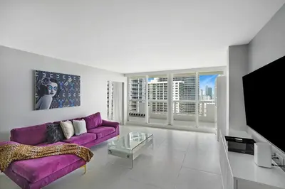 a living room with a purple couch and a tv at Higher Love! Water Views and Cool Vibes in Miami