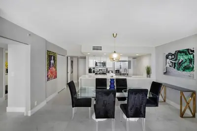 a dining room and kitchen with a glass table and chairs at Higher Love! Water Views and Cool Vibes in Miami
