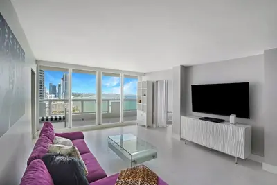 a living room with a purple couch and a tv at Higher Love! Water Views and Cool Vibes in Miami