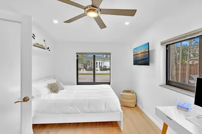 a white bedroom with a bed and a ceiling fan at Tropical Oasis With heated pool 10 mins airport & 5 mins Beach in Hollywood