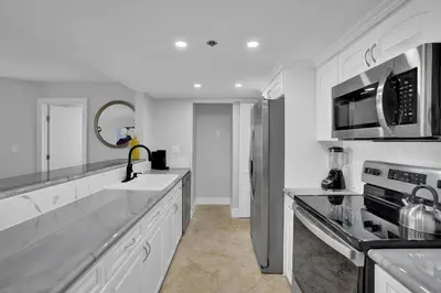 a white kitchen with a refrigerator and a sink at Euphoria - Miami Skyline & Water Views in Miami